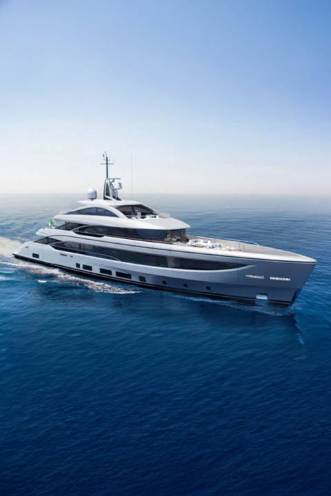 A sleek, modern yacht glides through calm, blue ocean waters under a clear sky.