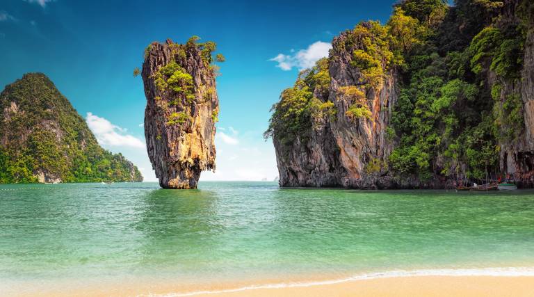 Towering limestone karsts rise majestically from the emerald waters of Thailand's Phang Nga Bay.