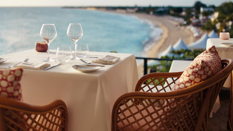 Dine al fresco with breathtaking ocean views from this elegantly set table on a tropical balcony.